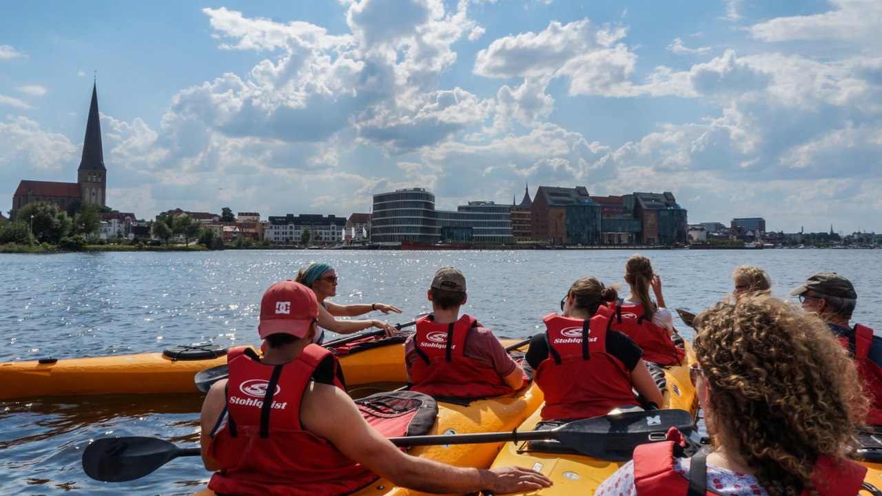 Paddling group with city scenery // &copy; Ronald Kley