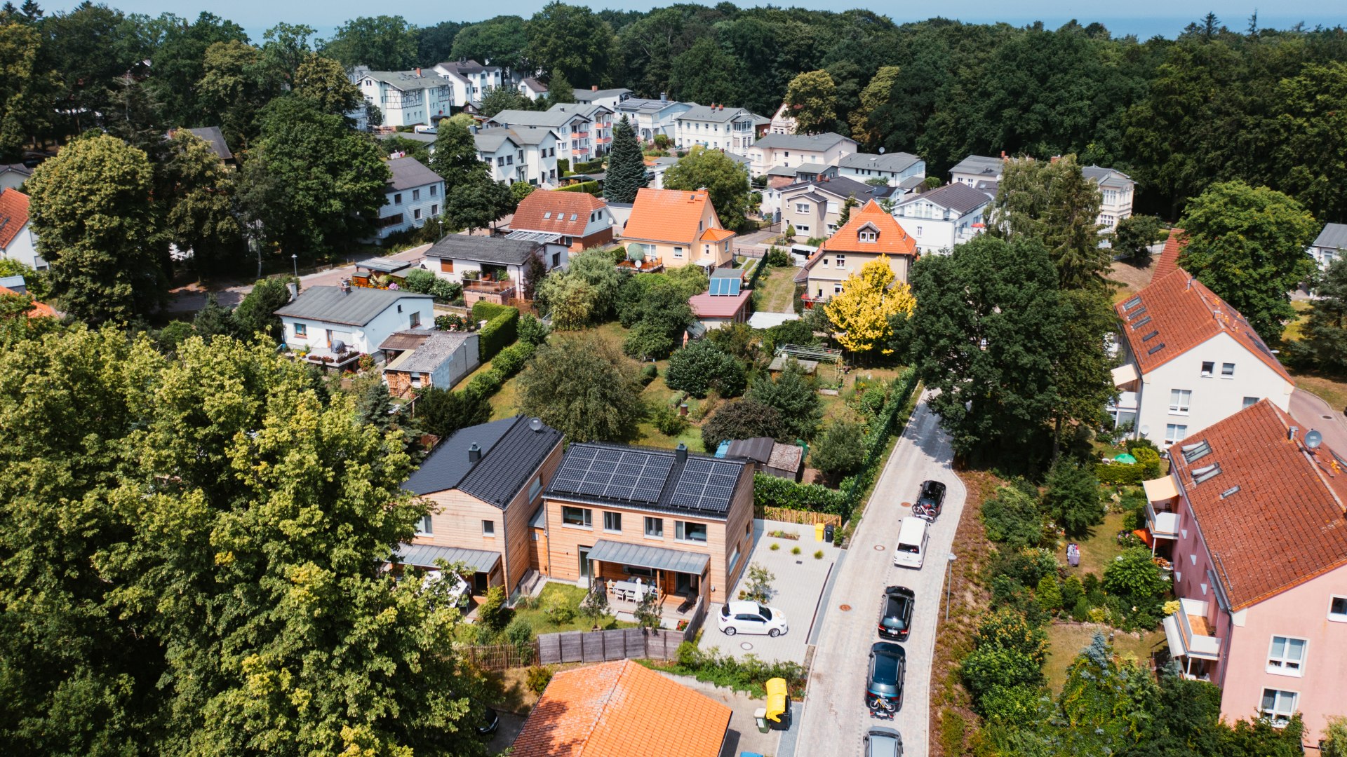 De vakantiehuizen &quot;beach grey&quot; en &quot;beach white&quot; tussen verschillende huizen vanuit de lucht
