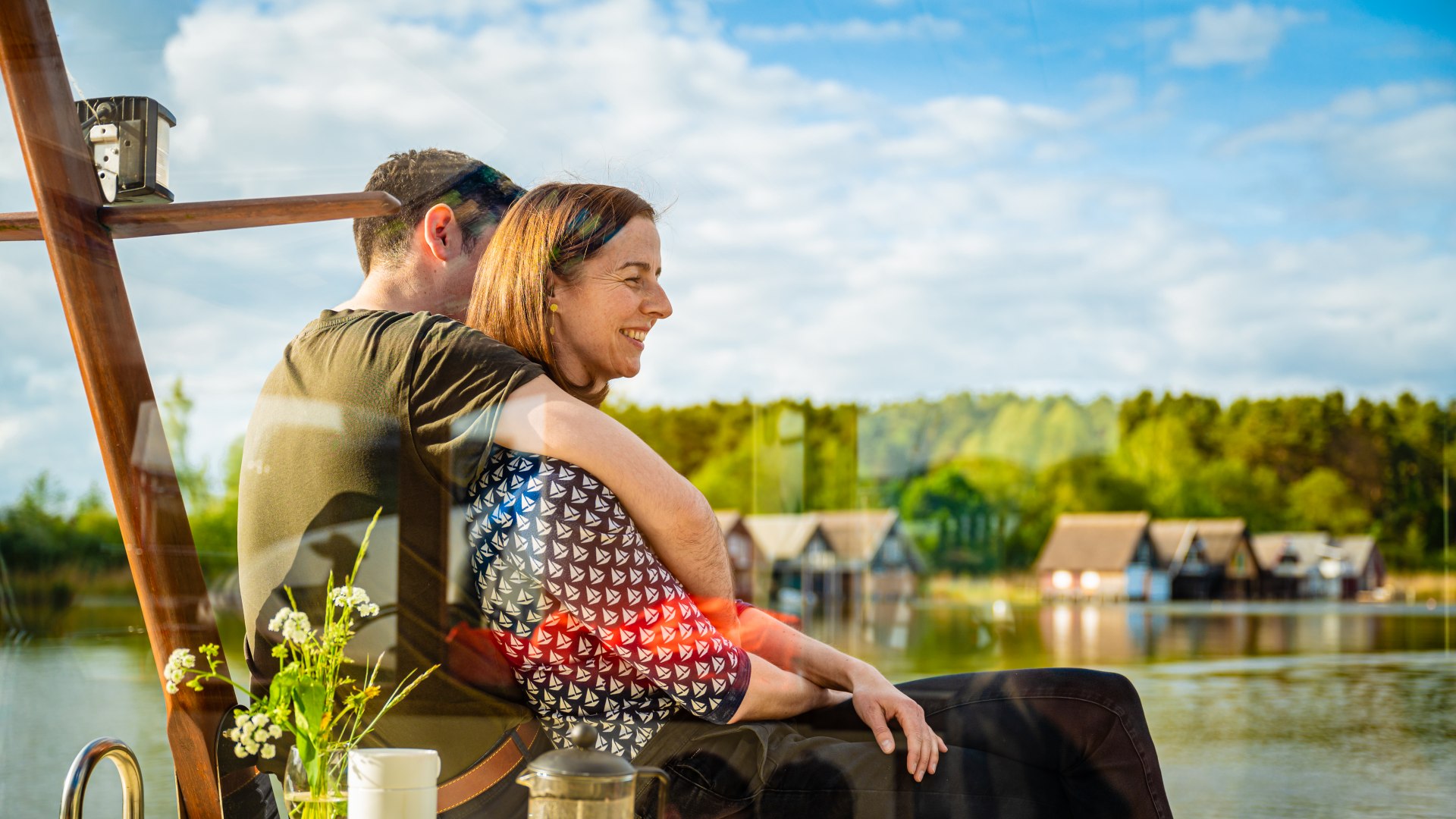 Since teens prefer to stay with each other, parents have plenty of time to enjoy togetherness moments., © TMV/Tiemann A couple sits on the deck of a houseboat and hugs each other