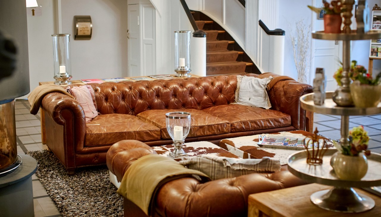 Inviting foyer with fireplace and cosy sofas at Gut Vorbeck, © Gut Vorbeck / Thomas Mandt