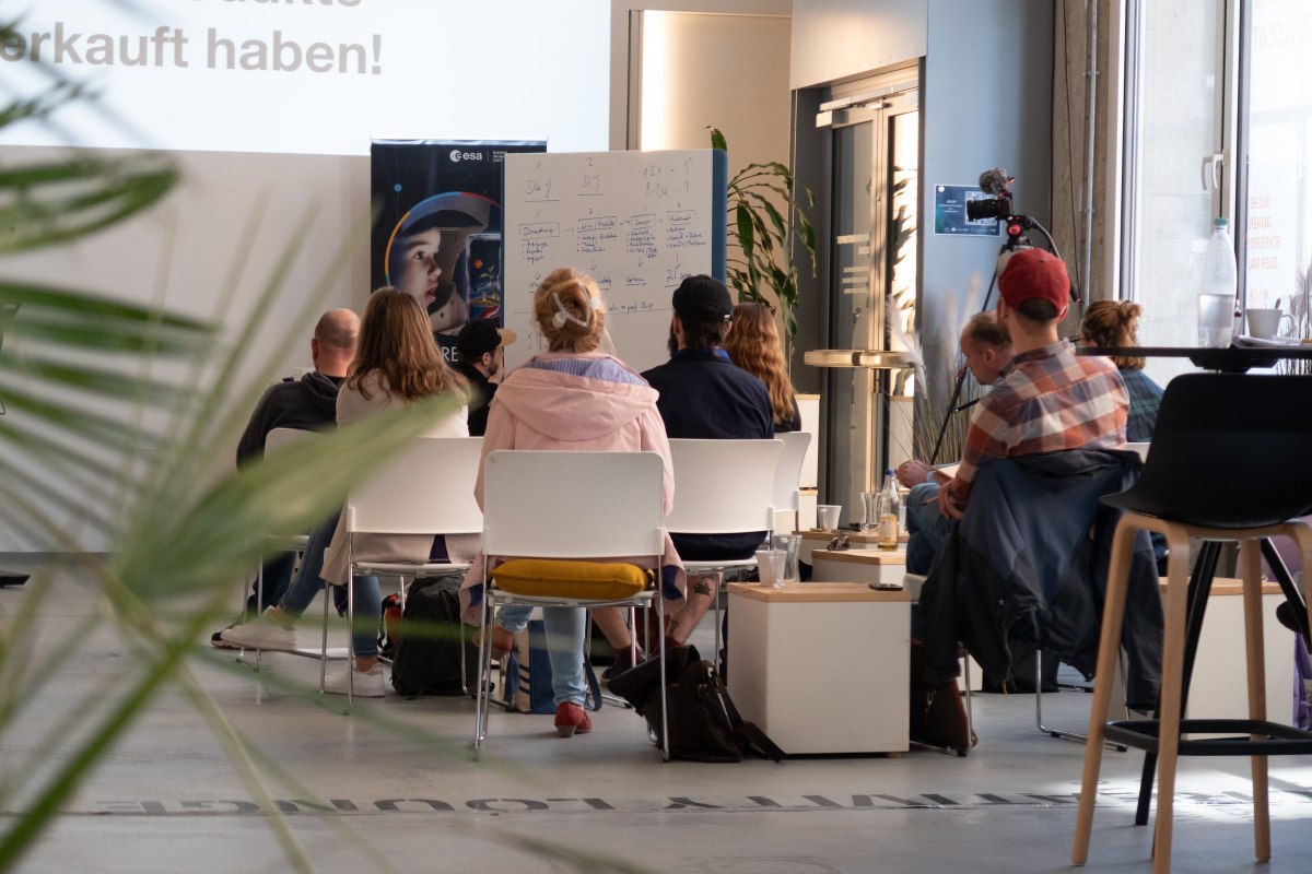 Workshop group seen from behind at InnovationPort Wismar in front of a whiteboard and roll-up banner // &copy; InnovationPort Wismar