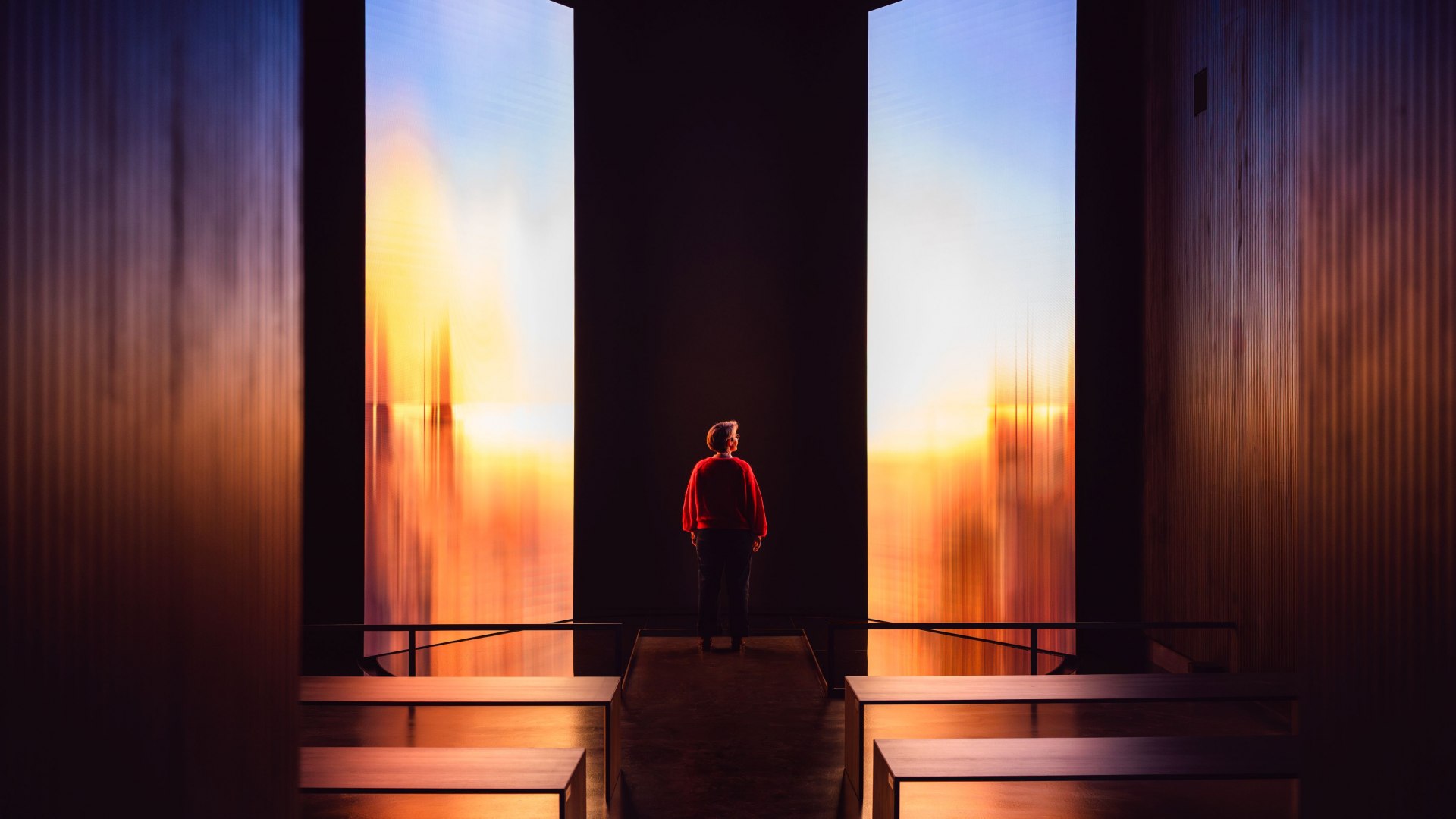 Gra światła i kolorów łączy się we wciągającą instalację w Pomorskim Muzeum Państwowym. Przestrzeń otwiera się między świetlnymi projekcjami, pozwalając odwiedzającym doświadczyć sztuki i atmosfery w nowy sposób - kulturalnej przyjemności w Greifswaldzie., © MV-T/Gross Birte Frenssen, kurator i zastępca dyrektora Państwowego Muzeum Pomorskiego, przed oświetloną instalacją artystyczną.