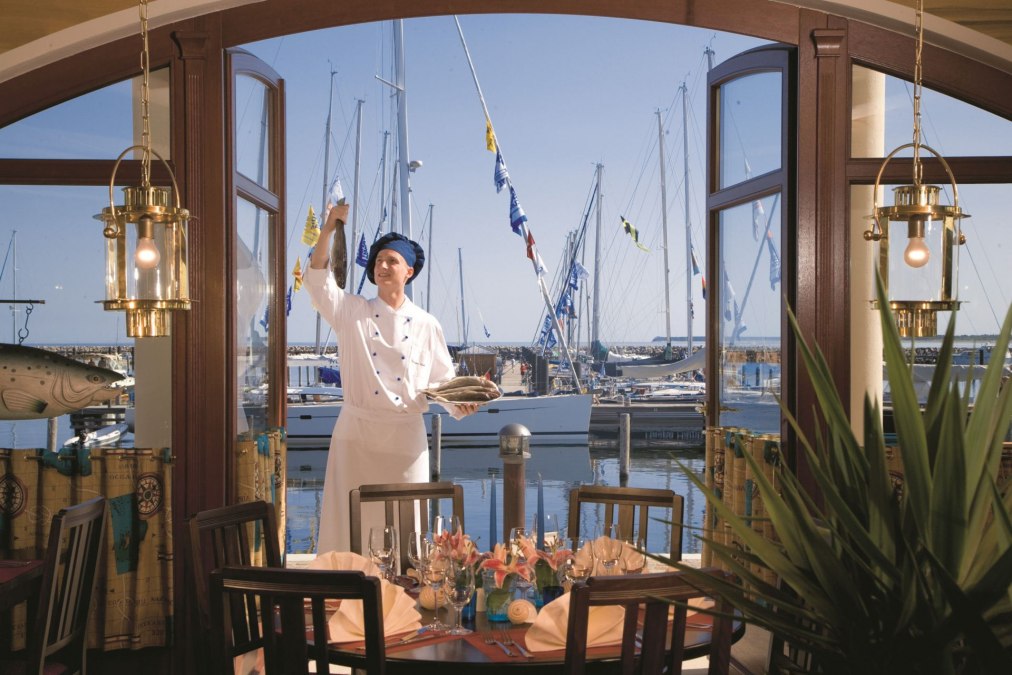 Geniet van je maaltijd in een stijlvolle ambiance met uitzicht op de Baltische Zee, waaronder Italiaanse pizza's en verse visgerechten., © Yachthafenresidenz Hohe Düne, www.hohe-düne.de