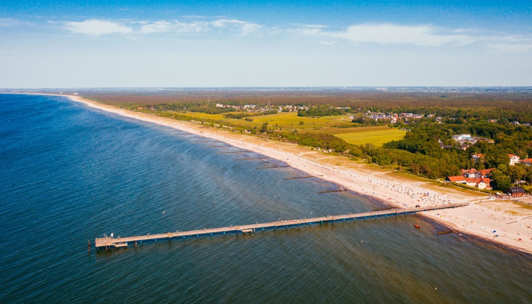 Aerial view of the Baltic Sea coast of Graal-Müritz with pier, sandy beach and coastal forest. // The pier juts out into the turquoise-blue water, the sandy beach stretches for miles along the coast. Graal-Müritz invites you to swim, walk and take a deep breath - between the Baltic Sea and green forests lies the open space for vacation moments. // © MV-T/Friedrich Aerial view of the Baltic Sea coast of Graal-Müritz with pier, sandy beach and coastal forest.