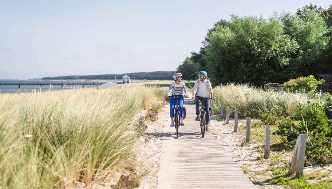 For kilometers, the route traces the coastline of the Baltic Sea., © TMV/Gross Cycle path along the coast of the seaside resort of Lubmin with two cyclists