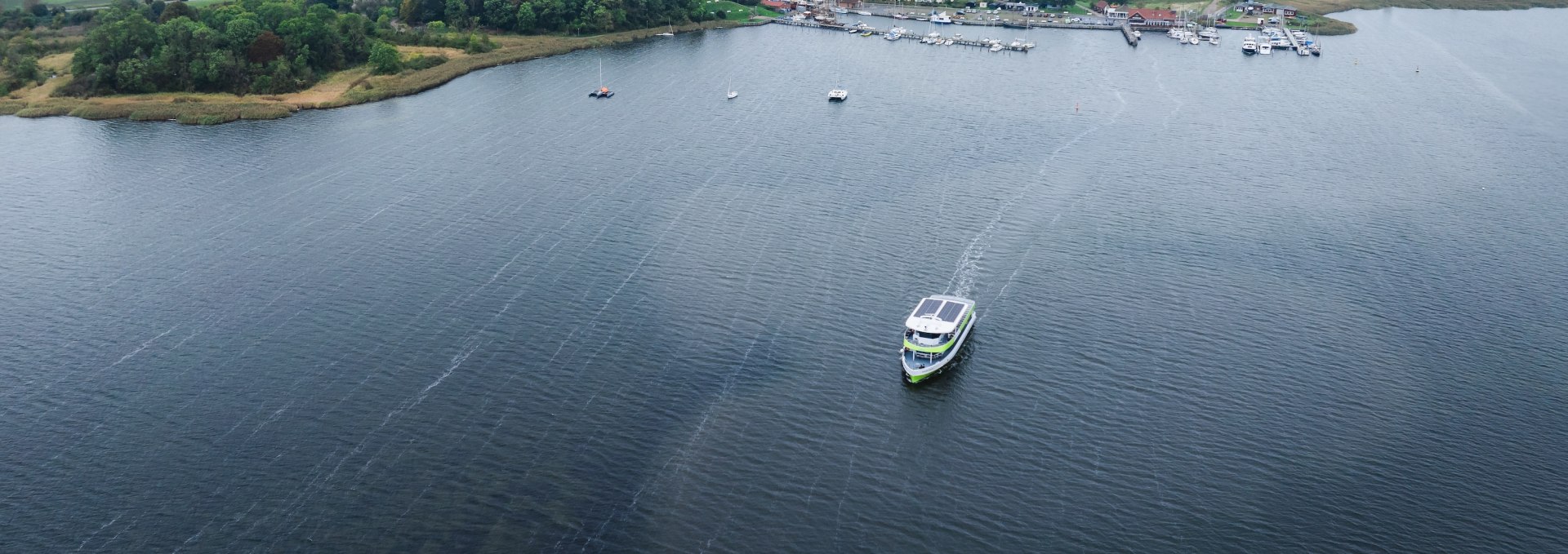  Electric ferry on the Baltic Sea between the port of Poel and Wismar, with a view of the coast.