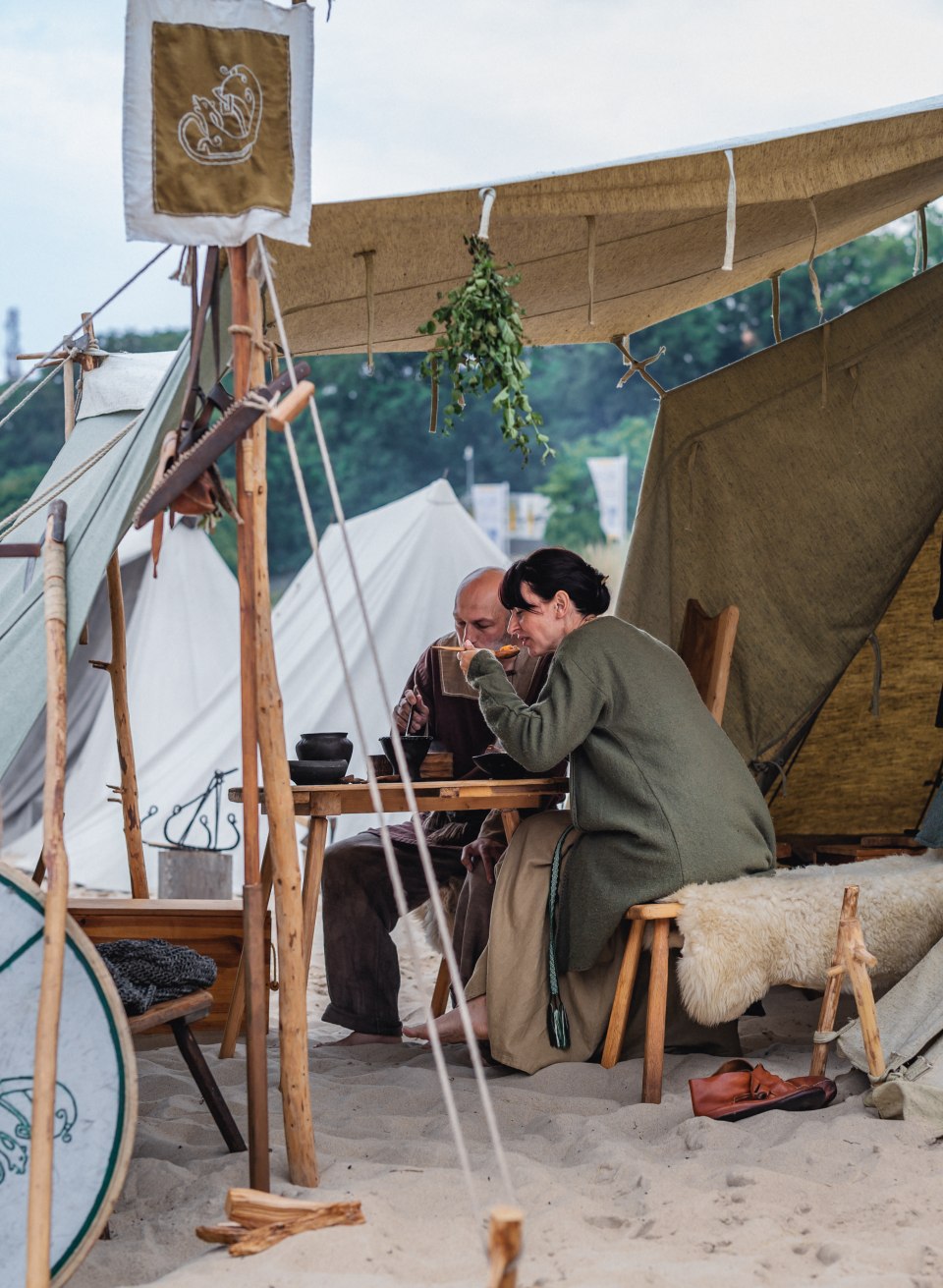 Wikingowie na festiwalu w Göhren jedzący lunch pod namiotem na plaży.