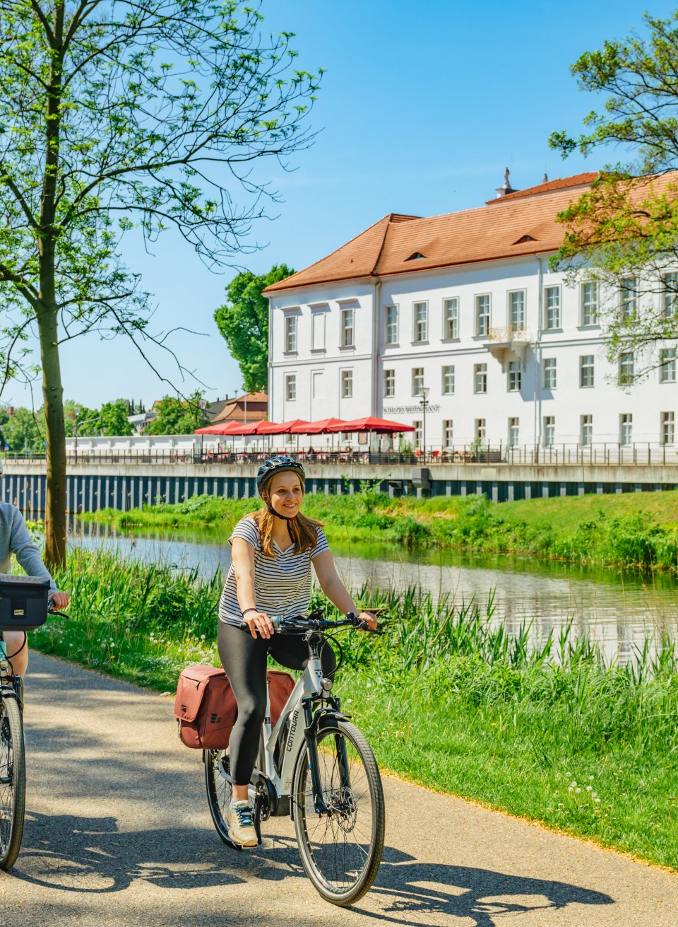 Mother and daughter cycle past Oranienburg Palace