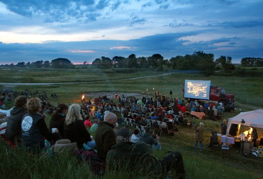 Openluchtbioscoop in een schilderachtig landschap: Veel bezoekers genieten van een filmvoorstelling in de open lucht. // &copy; Tobias Rank