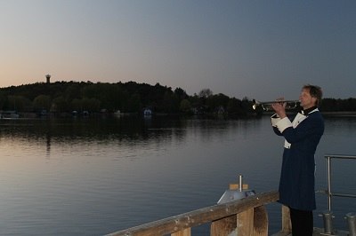 Trumpet solo with Mr. Viehstädt in guard uniform on the shore of the Krakow lake promenade // © Touristinformation Krakow am See Trumpet solo with Mr. Viehstädt in guard uniform on the shore of the Krakow lake promenade // © Touristinformation Krakow am See