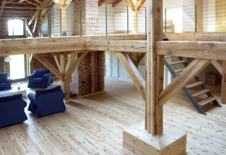 © Dieses stilvolle Loft kombiniert rustikalen Charme mit modernen Akzenten. Die massiven Holzbalken und das offene Raumkonzept harmonieren perfekt mit den gemütlichen Sitzgelegenheiten, während die freiliegenden Ziegelwände den historischen Charakter des Gebäudes bewahren. Die großzügige Galerie bietet zusätzlichen Raum und betont die luftige Atmosphäre dieses einzigartigen Wohnraums.