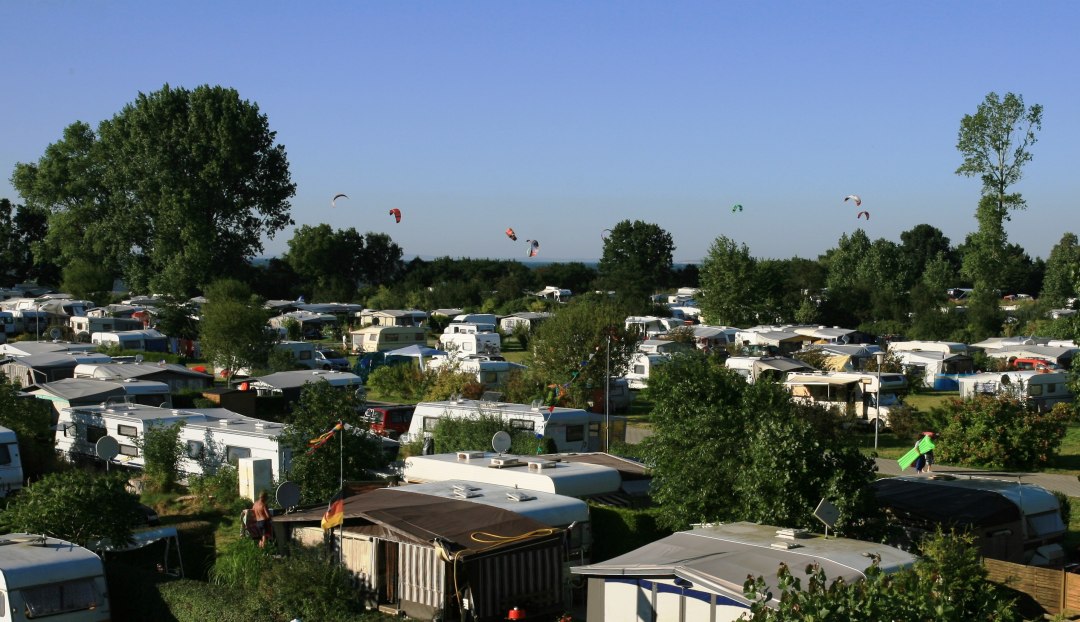 Uitzicht over het plein met kitesurfers op het water op de achtergrond, © Ferien- und Freizeitpark/Jastrow