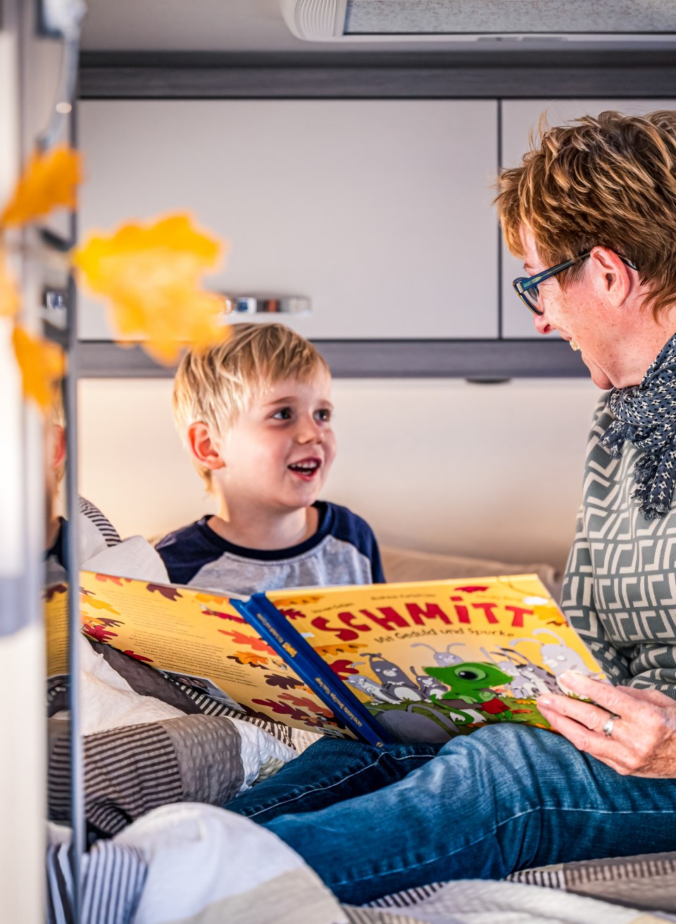 Ome leest haar kleinzoon een verhaaltje voor het slapengaan in de camper.