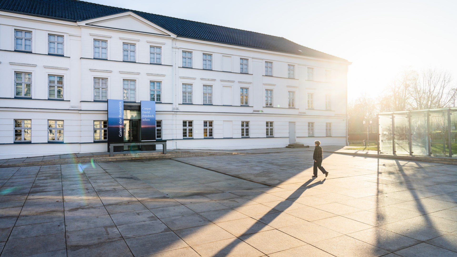 Wit classicistisch gebouw van het Pommers Staatsmuseum in Greifswald in het zonlicht.