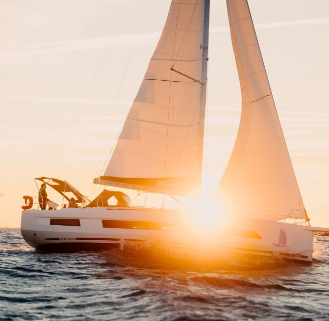 Sailboat with orange sails on the Baltic Sea off Warnemünde at sunset. // Golden light bathes the sails in warm colors - the horizon and freedom merge on the Baltic Sea off Warnemünde. The wind fills the sails, the waves rustle softly as the sun slowly sinks into the sea. // © MV-T/Petermann Sailboat with orange sails on the Baltic Sea off Warnemünde at sunset.
