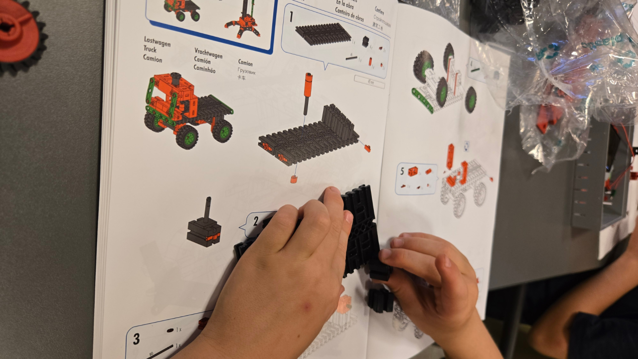 Two children's hands build a Lego car with the help of instructions // © Stadtbibliothek Stralsund Two children's hands build a Lego car with the help of instructions // © Stadtbibliothek Stralsund