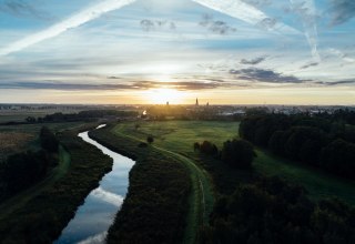 Sunrise over the Hanseatic City of Greifswald: a quiet river meanders through meadows, while church spires slowly become visible in the morning light on the horizon. Mecklenburg-Vorpommern awakens quietly. // © MV-T/Gänsicke Sunrise over the Hanseatic City of Greifswald: a quiet river meanders through meadows, while church spires slowly become visible in the morning light on the horizon. Mecklenburg-Vorpommern awakens quietly. // © MV-T/Gänsicke