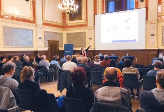 Audience at a lecture in the auditorium; concentrated listening situation with a view of the stage and presentation. // &copy; Koller