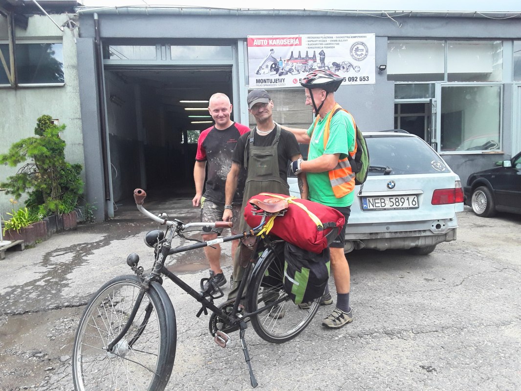 Op de voorgrond een fiets met rode bagage, daarachter Reinhard Klette met twee Poolse burgers., &copy; Reinhard Klette