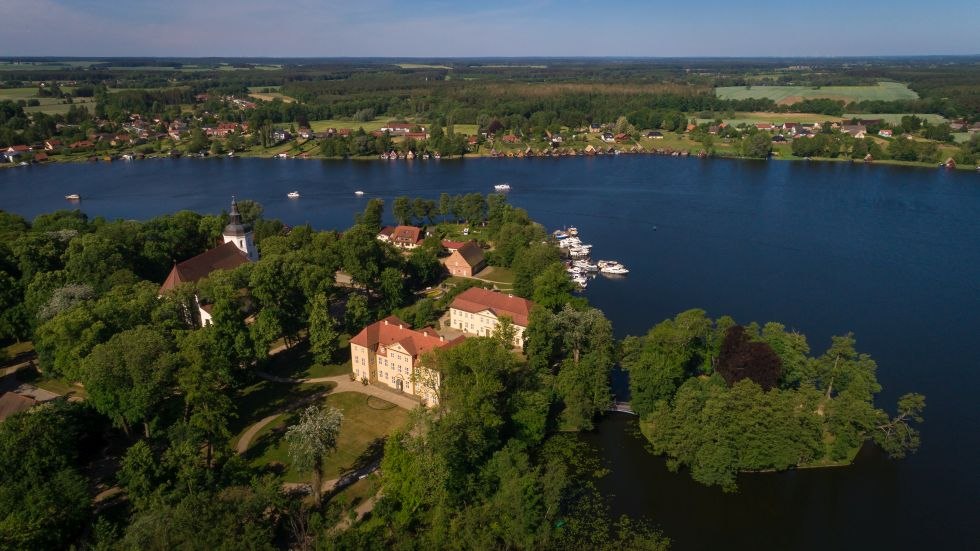 Zamek Mir&oacute;w z błyszczącym Jeziorem Mirowskim w tle // &copy; MV-T/Myroad
