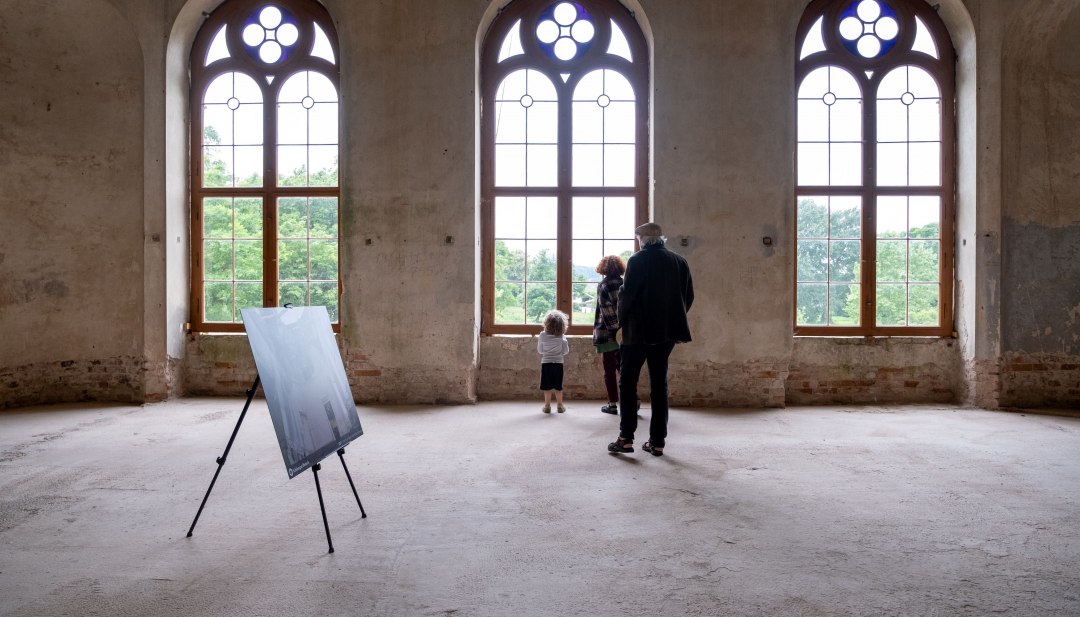 Wystawa rodzinna w zabytkowej sali z gotyckimi oknami w zamku Broock.