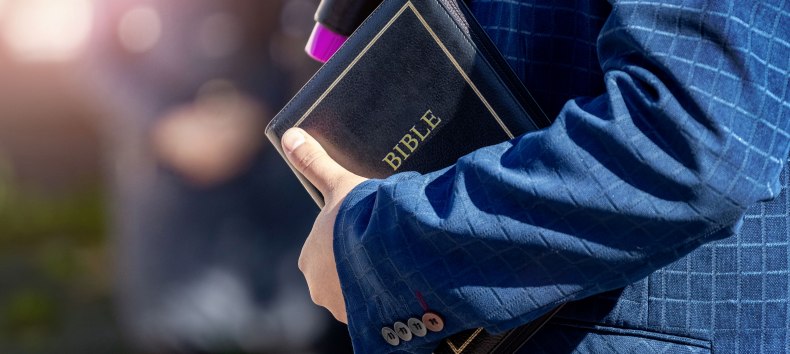 A man holds a Bible in his hand. // &copy; AdobeStock