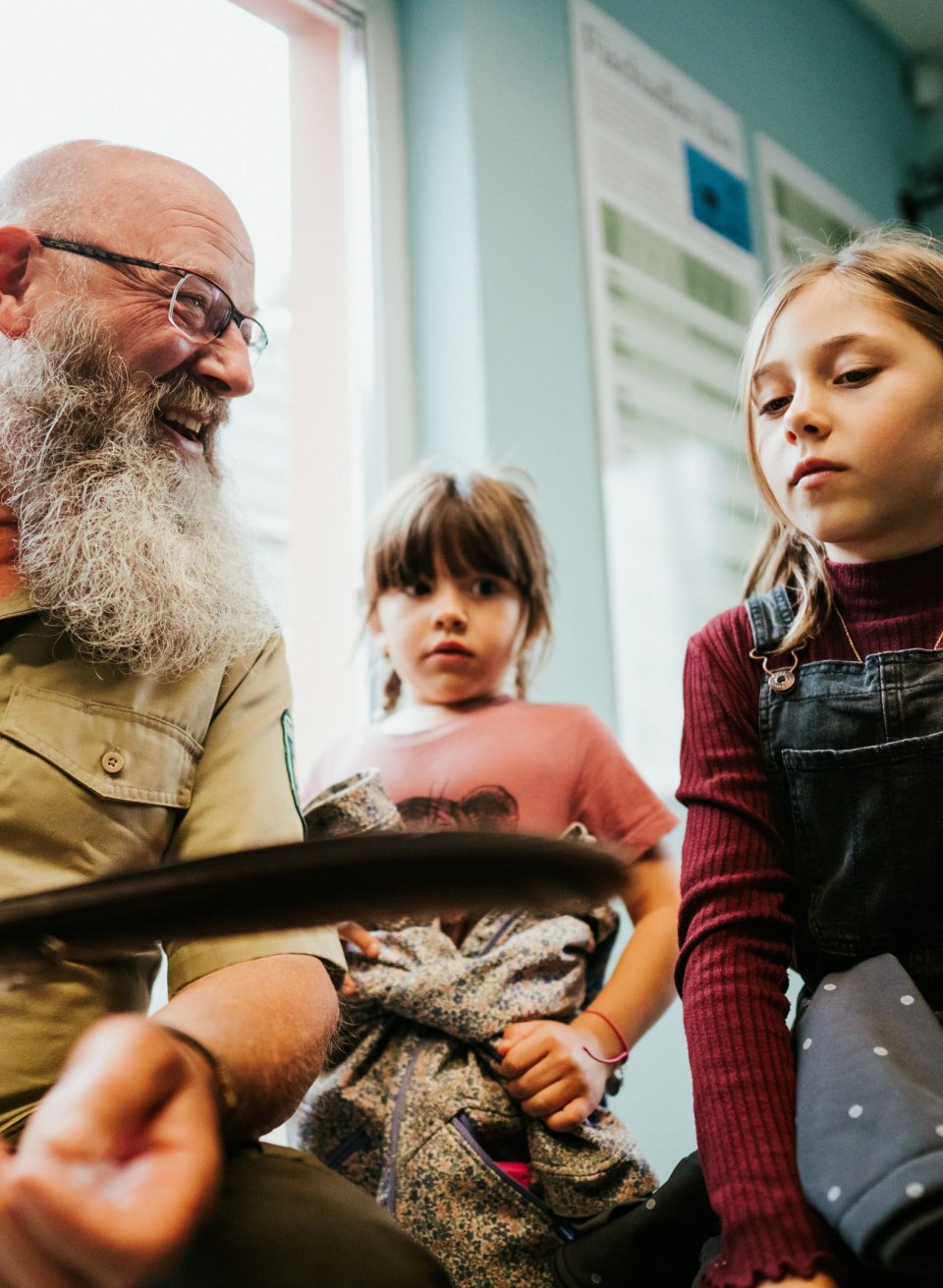 Een ranger in het M&uuml;ritz National Park legt twee nieuwsgierige kinderen tijdens een arendsafari spannende details uit over het plaatselijke vogelleven. Met een veer in zijn hand brengt hij hen op een levendige manier dichter bij de fascinerende geheimen van de natuur.