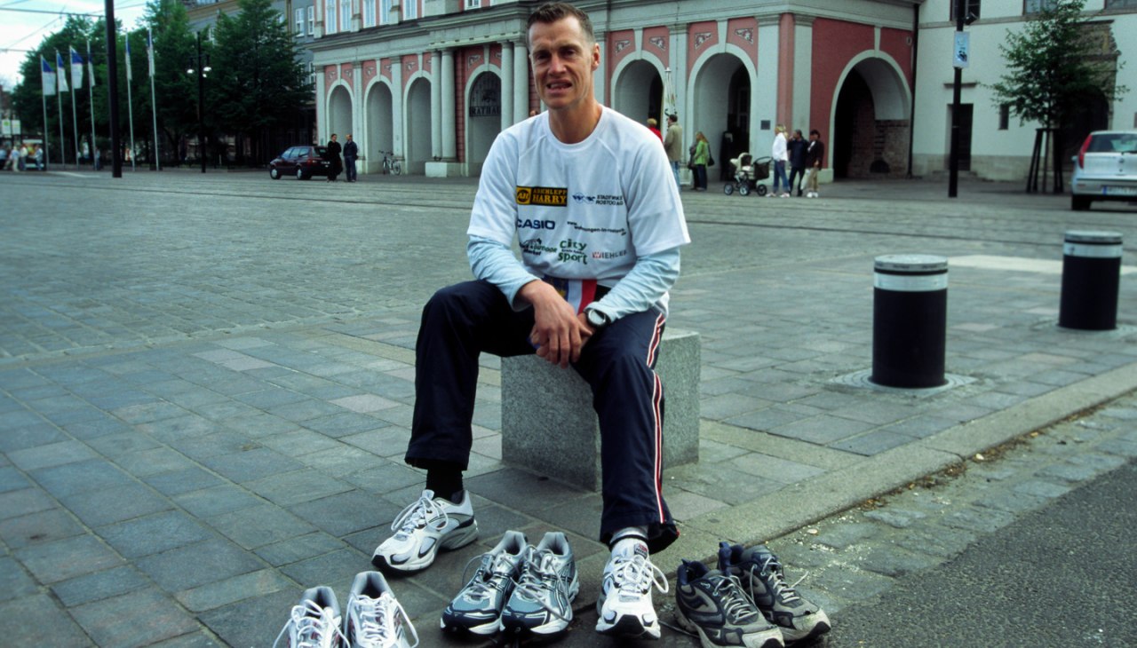 Ronald Prokein siedzi w mieście, mając przed sobą 3 pary butów do biegania., © Ronald Prokein