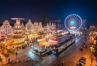 Glittering lights and a festive atmosphere - the Rostock Christmas market delights visitors with historic facades, fragrant treats and a shining Ferris wheel in the middle of the old town., &copy; Erik Gross