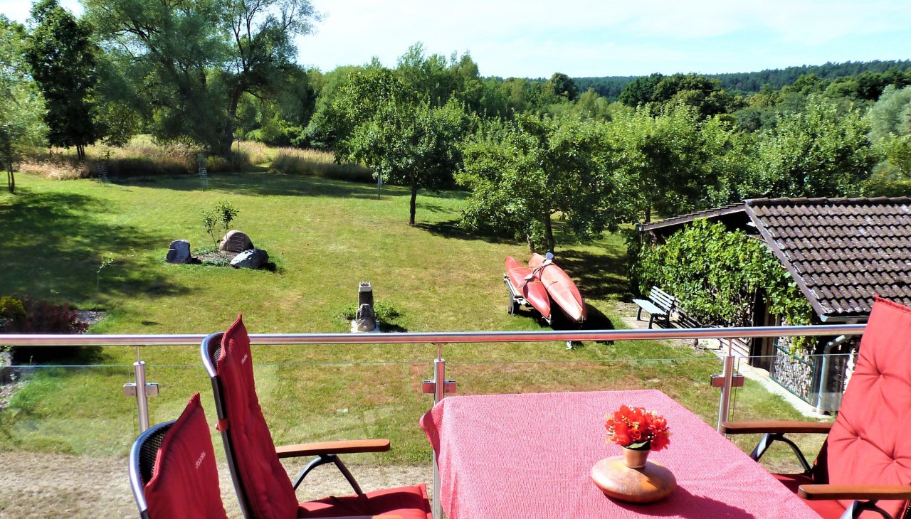 View from the balcony to the sunbathing lawn with campfire place, © Manfred Sohn