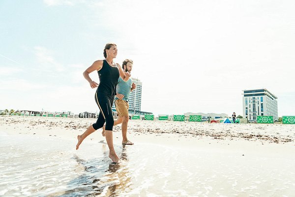 Een atleet rent op het strand in Warnemünde in de zomer