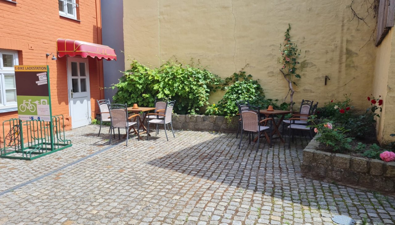Wewnętrzny dziedziniec z miejscami do siedzenia i stacją ładowania rowerów elektrycznych, © Tourist-Information Malchow Wewnętrzny dziedziniec z miejscami do siedzenia i stacją ładowania rowerów elektrycznych, © Tourist-Information Malchow