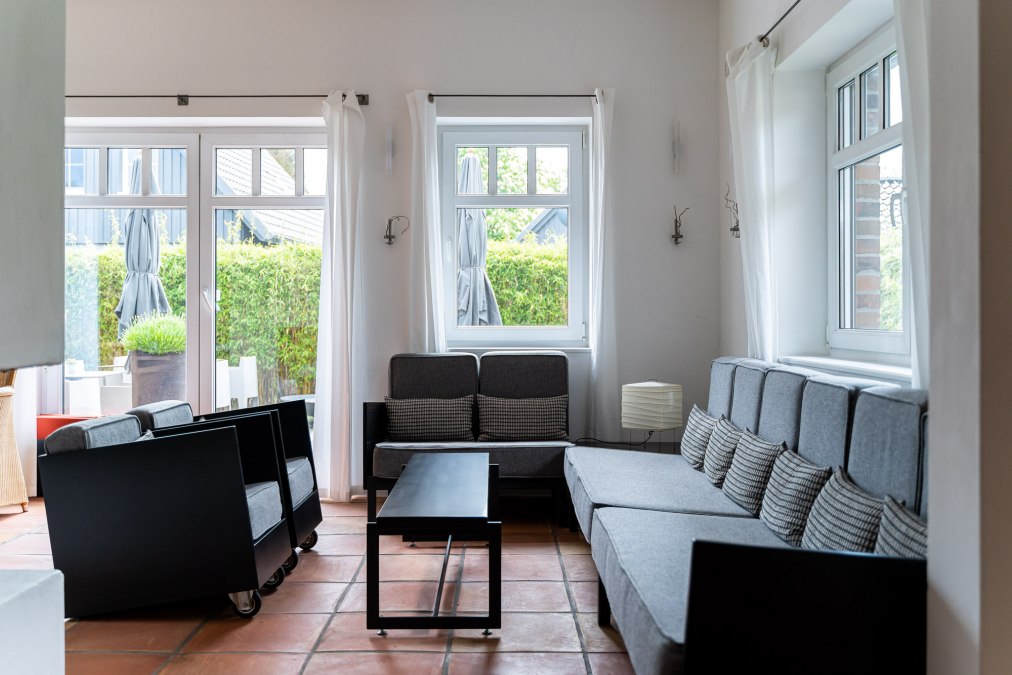 Jasny i stylowo urządzony salon z dużymi oknami wpuszczającymi mnóstwo naturalnego światła. Szare sofy i fotele z minimalistycznymi czarnymi akcentami zachęcają do relaksu. Ciepłe podłogi z terakoty i proste białe zasłony nadają pomieszczeniu relaksującą i zachęcającą atmosferę., © Hotel Carpe Diem Jasny i stylowo urządzony salon z dużymi oknami wpuszczającymi mnóstwo naturalnego światła. Szare sofy i fotele z minimalistycznymi czarnymi akcentami zachęcają do relaksu. Ciepłe podłogi z terakoty i proste białe zasłony nadają pomieszczeniu relaksującą i zachęcającą atmosferę., © Hotel Carpe Diem