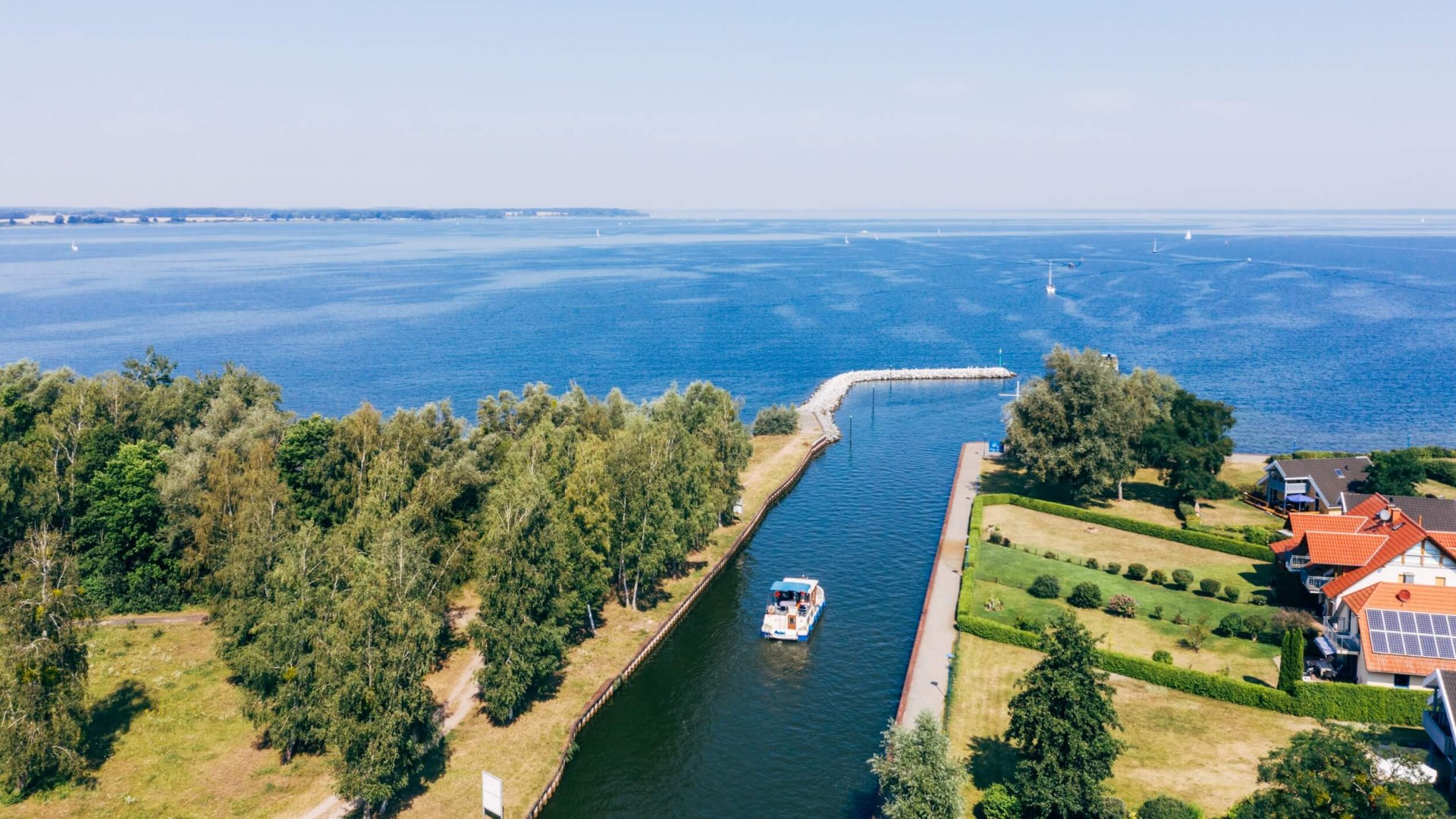 Micha steers the houseboat through the canal towards Müritz. // © MV-T/Gänsicke Micha steers the houseboat through the canal towards Müritz. // © MV-T/Gänsicke