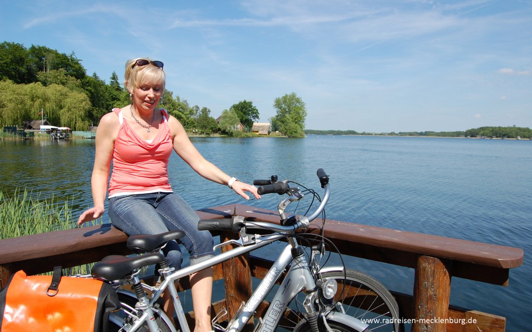 A cyclist sits on railings by the lake., © Ralf Tetmeyer, radreisen-mecklenburg