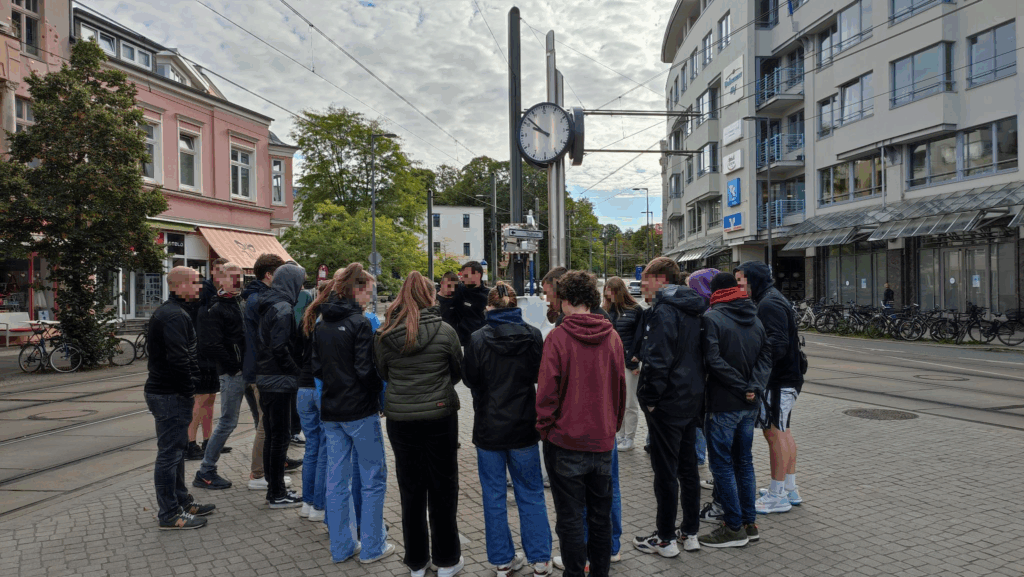 Young people stand in a circle during the city tour, © Lichtenhagenarchiv