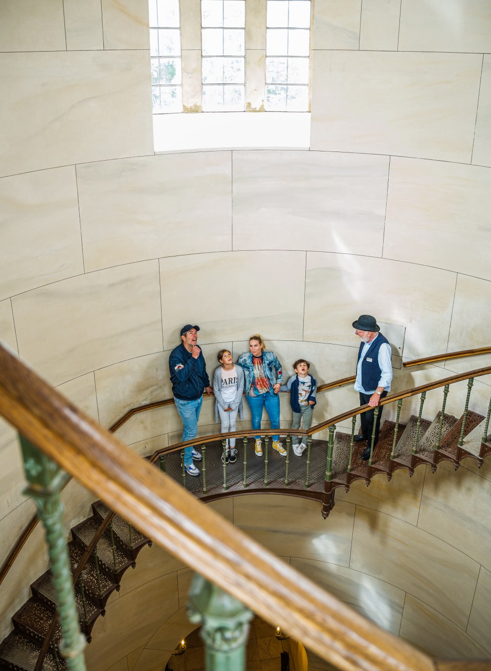 A family stands on the spiral staircase in Granitz Castle that leads up to the tower.