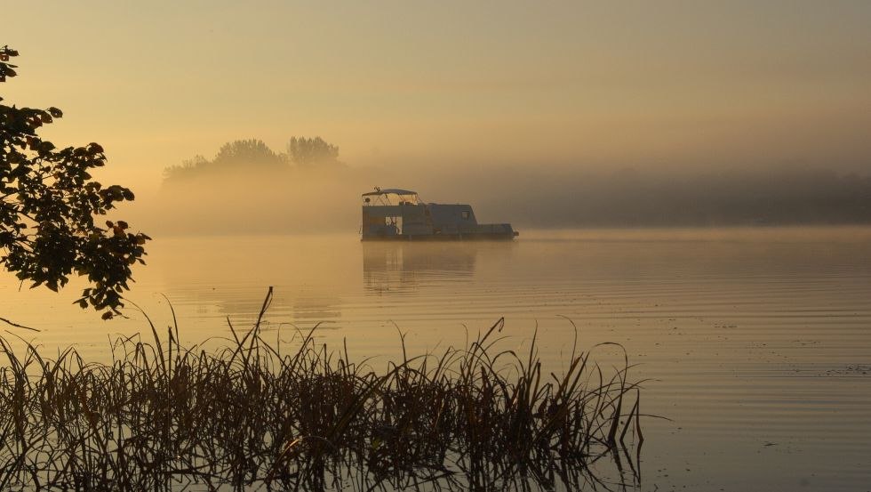 Zonsopgang op het meer: een drijvende caravan te midden van alles, © freecamper