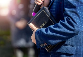 A man holds a Bible in his hand. // &copy; AdobeStock