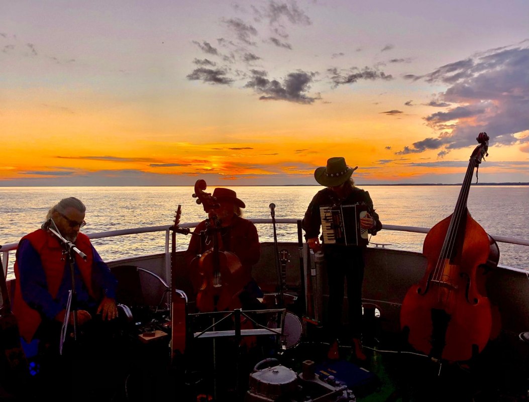 The Irish Cowboys on the stern of the MS Nordost, with the sunset over the Szczecin Lagoon behind them. // &copy; Sarah Stuth