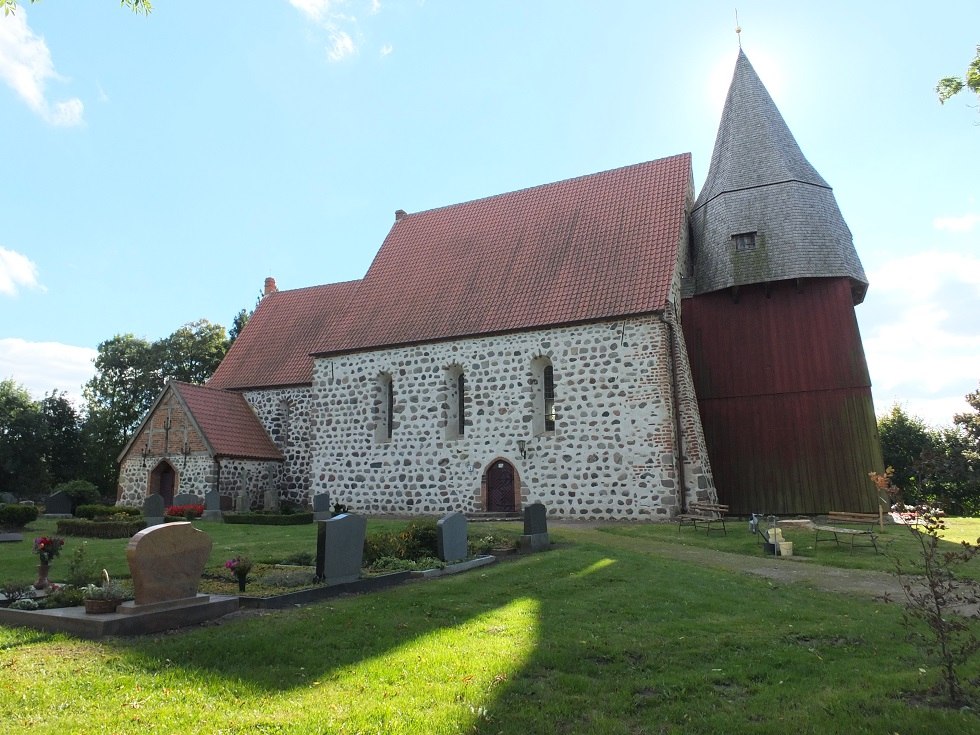 Widok z boku na kościół z kamienia polnego Tribohmer z drewnianą dzwonnicą // © Martin Hagemann Widok z boku na kościół z kamienia polnego Tribohmer z drewnianą dzwonnicą // © Martin Hagemann