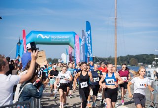 Start photo of the Rostock Women's Run 2024 at the Wasserkante in good weather. Many spectators motivate the participants at the start, © PE