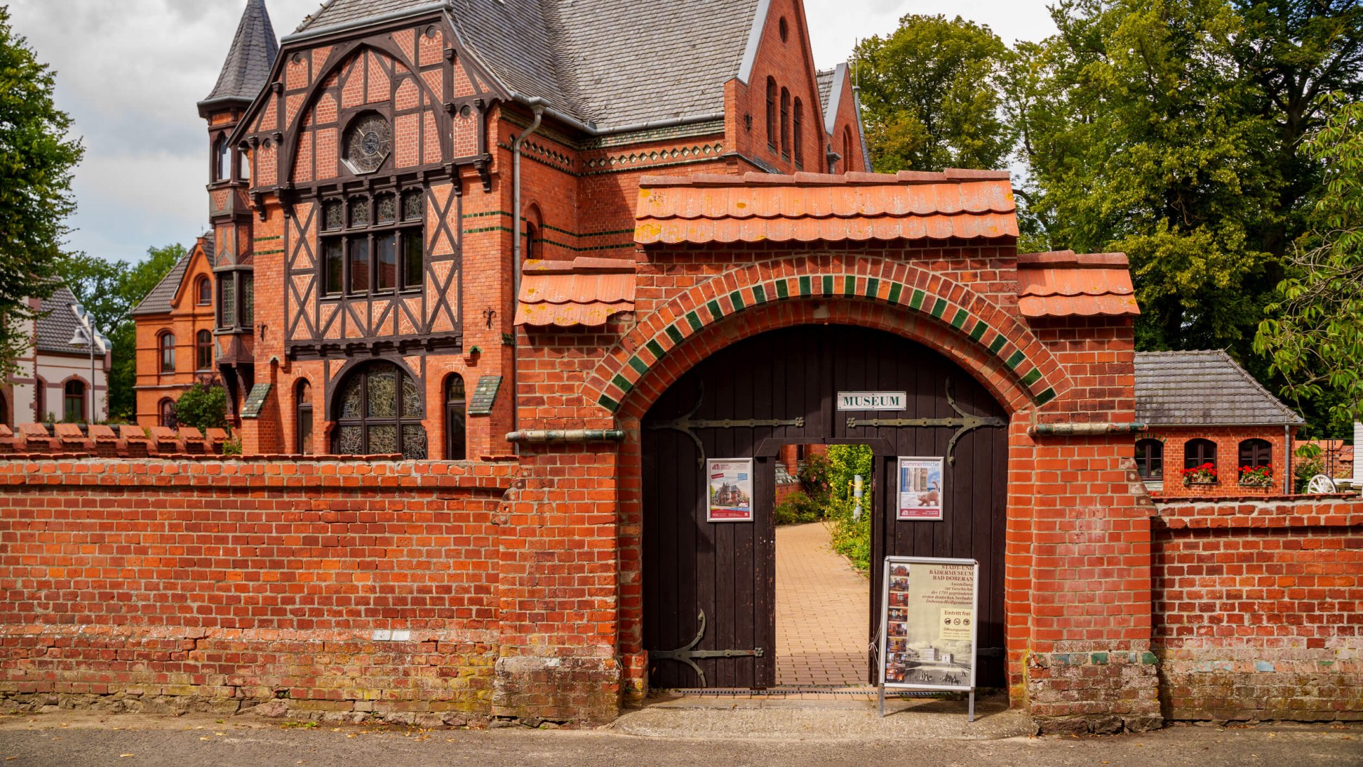 The town and spa museum in the Möckelhaus in Bad Doberan, a historic building with striking brick and half-timbered architecture, surrounded by a red brick wall.