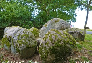 Widok niektórych kamieni megalitycznego grobowca "Goldbusch" z tablicą informacyjną // © Archäo Tour Rügen Widok niektórych kamieni megalitycznego grobowca "Goldbusch" z tablicą informacyjną // © Archäo Tour Rügen