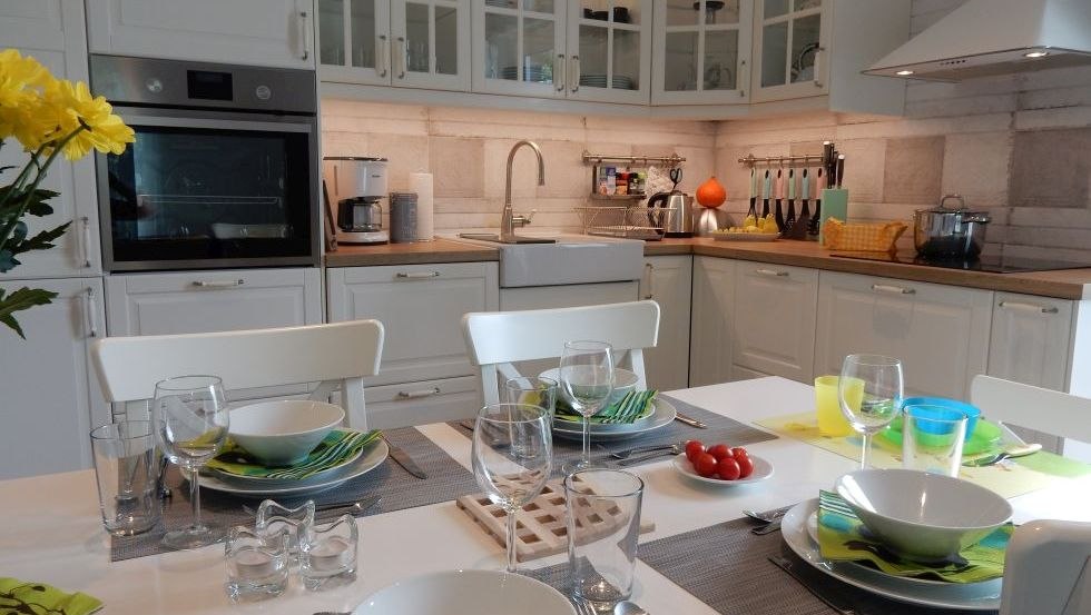 Tijd met het gezin in de moderne keuken met aangrenzende eethoek, © @cramer