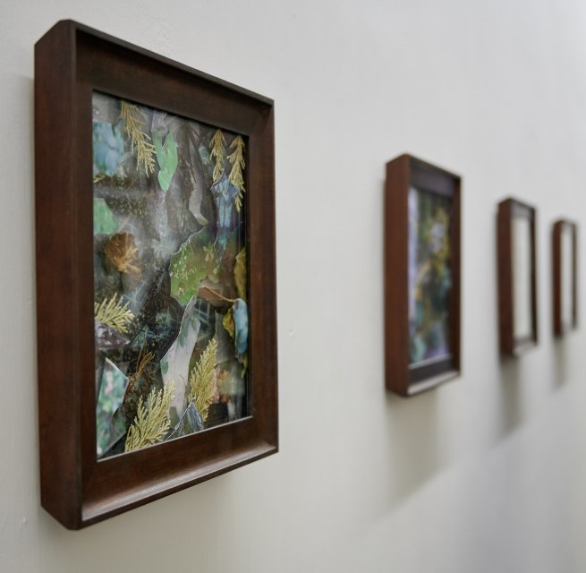 Bezoekers bekijken ingelijste natuurcollages in een heldere tentoonstelling tijdens de KUNST HEUTE evenementenserie.