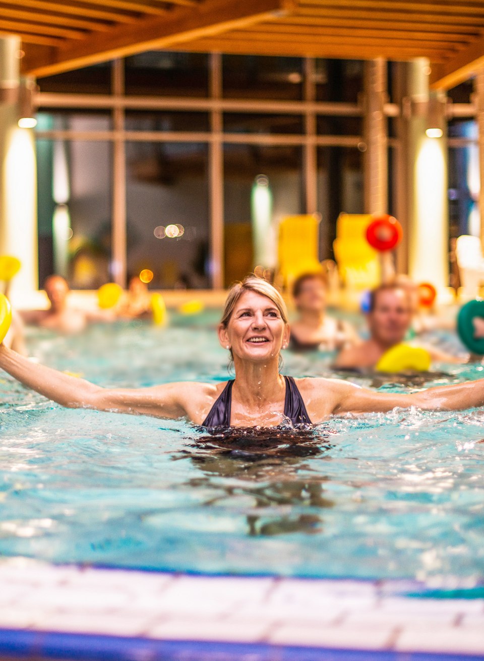 Kilka os&oacute;b uprawia gimnastykę wodną w basenie w centrum spa Waren(M&uuml;ritz)