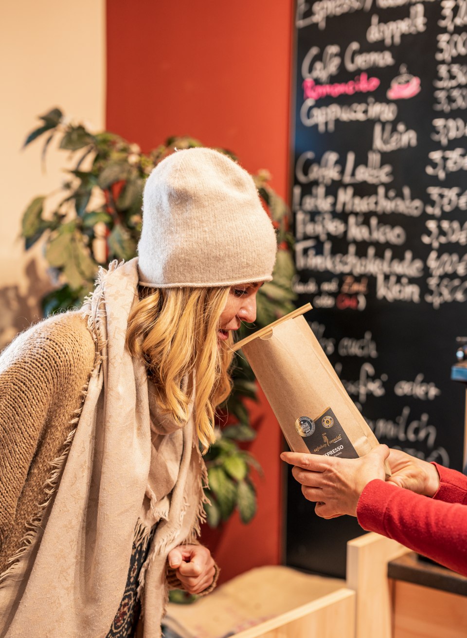 Kobieta wącha otwartą torebkę świeżej kawy - w kawiarni Especial zawsze unosi się aromat drobnych ziaren kawy. // W kawiarni Especial zawsze unosi się aromat doskonałej kawy ziarnistej // © MV-T/Tiemann Kobieta wącha otwartą torebkę świeżej kawy - w kawiarni Especial zawsze unosi się aromat drobnych ziaren kawy.