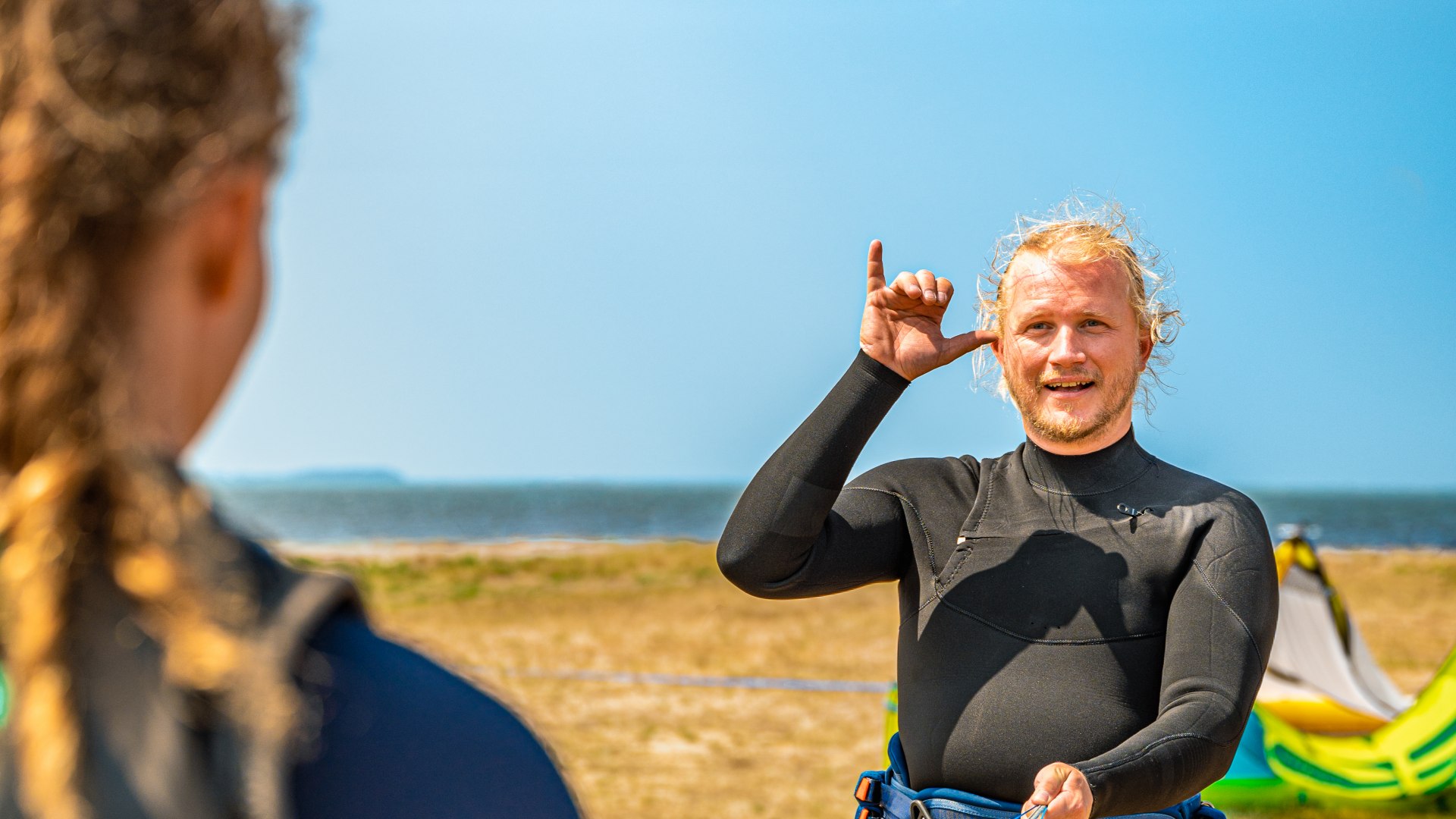 Kitesurfing lessons in sign language - The instructor explains to the student on Ummanz. // Everything clear? Luisa is deaf. So is her instructor Patrick. DeafVentures is the first certified kitesurfing school in Germany for the deaf. // © MV-T/Tiemann Kitesurfing lessons in sign language - The instructor explains to the student on Ummanz.