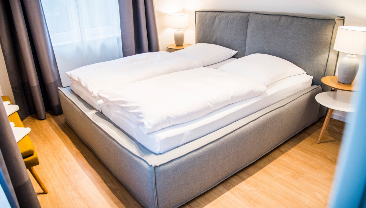 Jedna sypialnia wyposażona jest w łóżko podwójne, a druga w dwa łóżka pojedyncze, © Lichthof Neubrandenburg Jedna sypialnia wyposażona jest w łóżko podwójne, a druga w dwa łóżka pojedyncze, © Lichthof Neubrandenburg